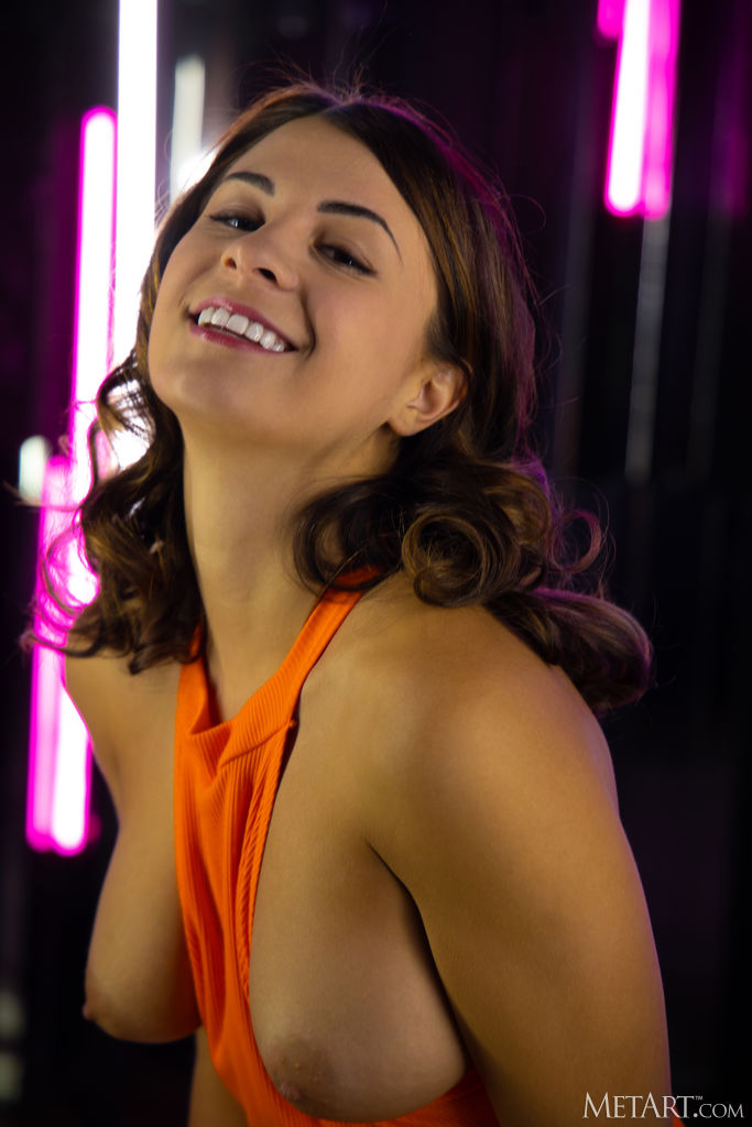 Alice Kelly Voluptuous Beauty Tugs At Her Vibrant Orange Bodysuit